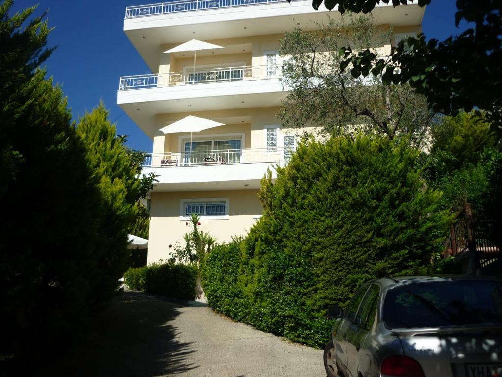 un edificio blanco con un coche aparcado delante de él en Villa Basilika, en Vlorë