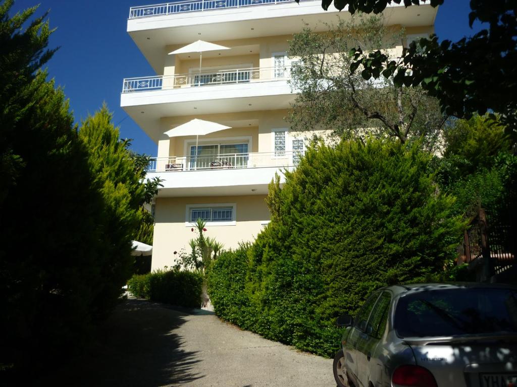 a white building with a car parked in front of it at Villa Basilika in Vlorë