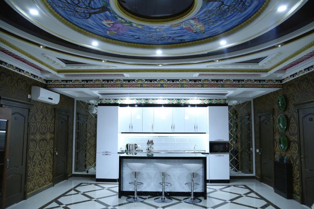 a kitchen with a coffered ceiling and white cabinets at Sunrise Apartments in Dushanbe