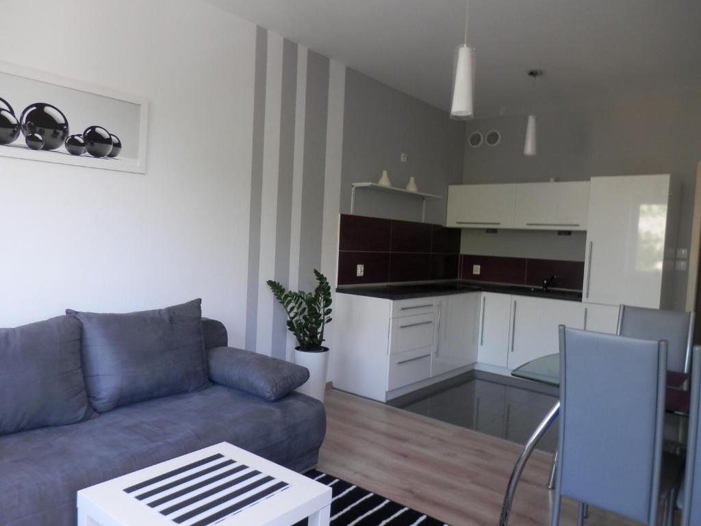 a living room with a couch and a kitchen at Apartamenty Iz-Mir in Kołobrzeg