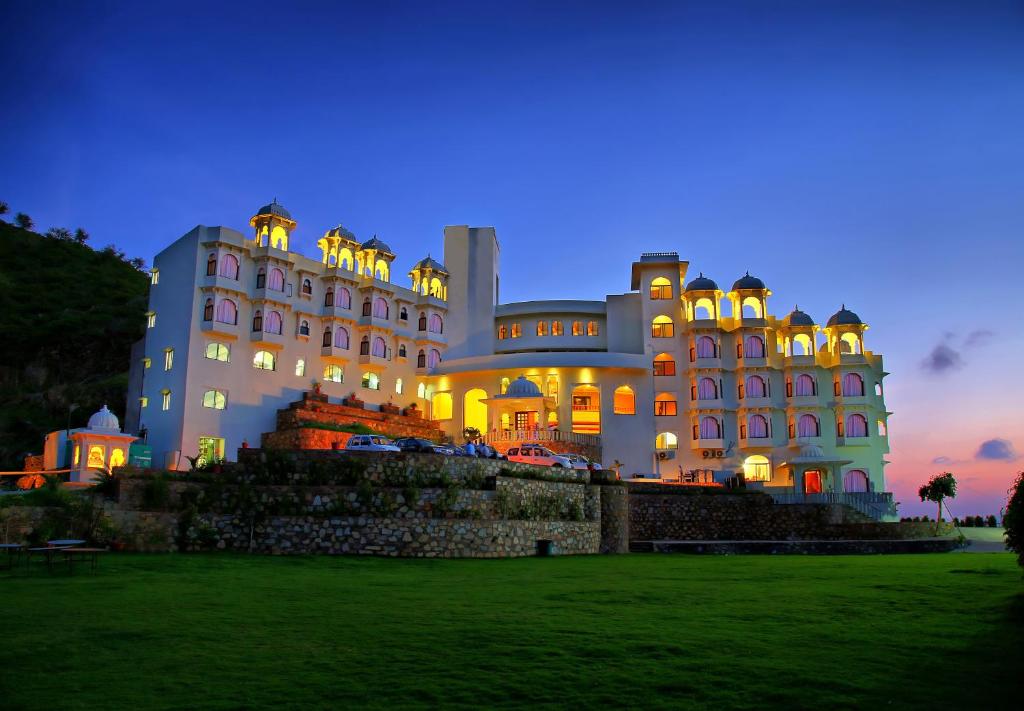 a large building at night with the lights on at Bhairavgarh Palace Udaipur in Udaipur