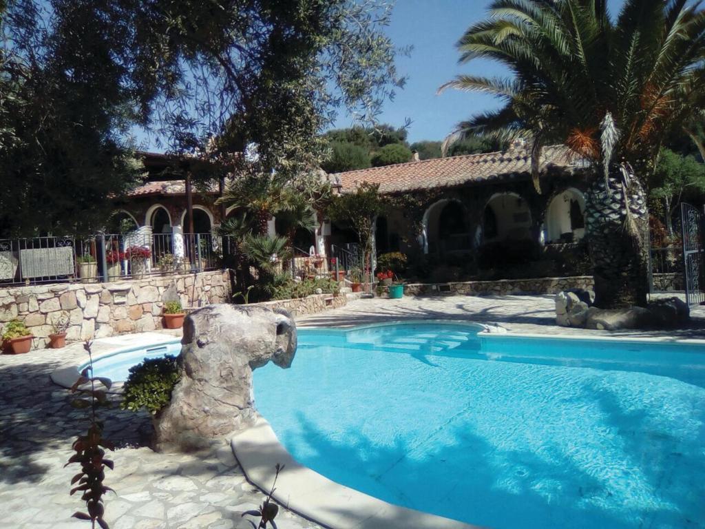 a swimming pool with a statue of a bear next to a house at Villa Adriana - Torre delle Stelle - mini appartamenti - Cagliari Villasimus Sardegna in Torre delle Stelle