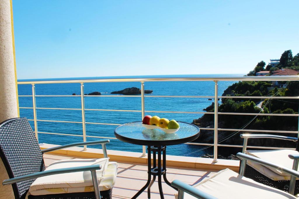 a table on a balcony with a view of the ocean at Apartments Gran Sasso in Ulcinj