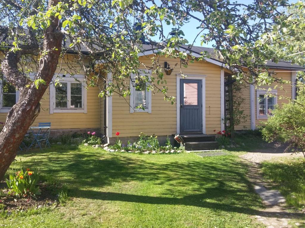 a yellow house with a tree in the yard at Vacation Home in Old Town Porvoo in Porvoo