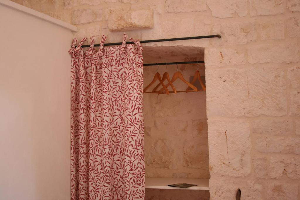 a shower curtain in a room with a brick wall at Casolare Capitolo in Cisternino