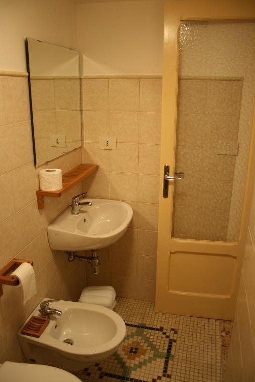 a bathroom with a sink and a toilet and a mirror at Casolare Capitolo in Cisternino