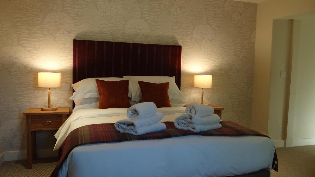 a bedroom with a large bed with towels on it at The Colesbourne Inn in Colesbourne