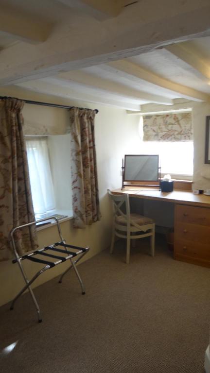 a room with a desk and a chair next to a window at The Colesbourne Inn in Colesbourne