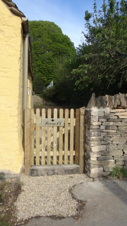 a wooden gate in front of a house at The Colesbourne Inn in Colesbourne