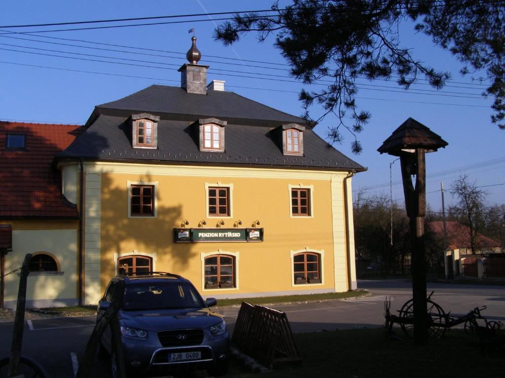 een groot geel gebouw met een zwart dak bij Hotel Rytířsko in Jamné