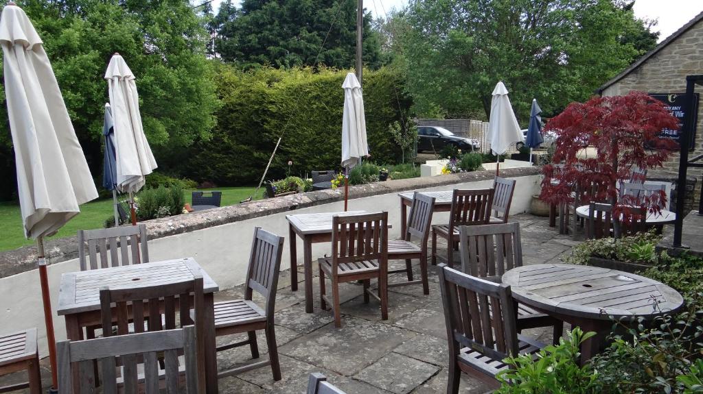 a group of tables and chairs with white umbrellas at The Colesbourne Inn in Colesbourne