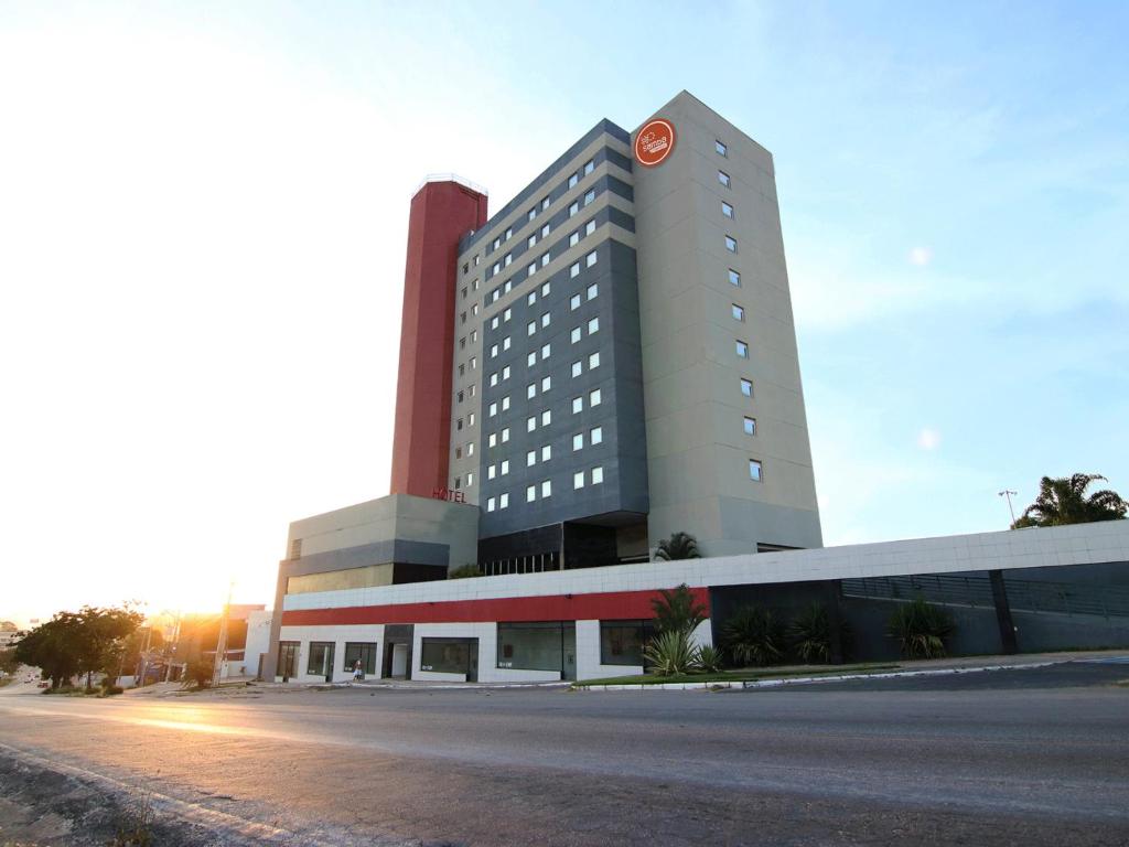 un gran edificio con un reloj rojo encima en Samba Itaboraí, en Itaboraí
