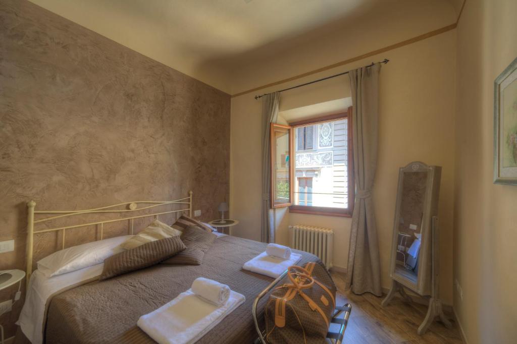 a bedroom with a bed with two towels on it at Piazza Signoria Suite in Florence