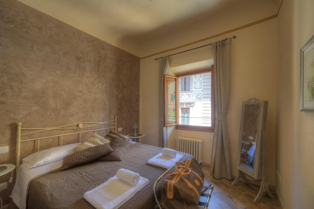 una camera da letto con un letto e due asciugamani di Piazza Signoria Suite a Firenze