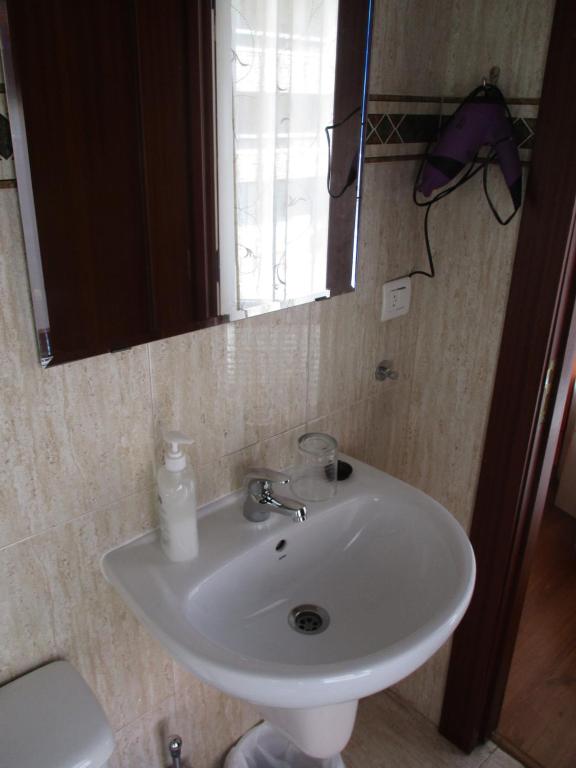 a white sink in a bathroom with a mirror at Hostal Becares in Palencia