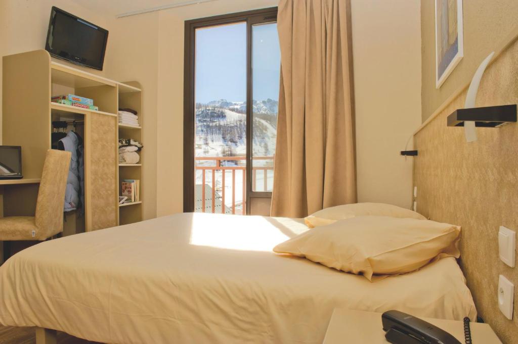 a hotel room with a bed and a window at VTF Le Grand Hotel in Montgenèvre