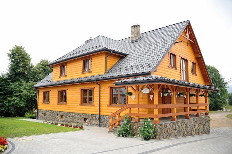 a large wooden house with a black roof at Chata u Rysia in Hoczew