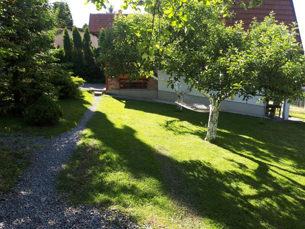 a shady yard with a tree and a building at Holiday Home Amila in Visoko