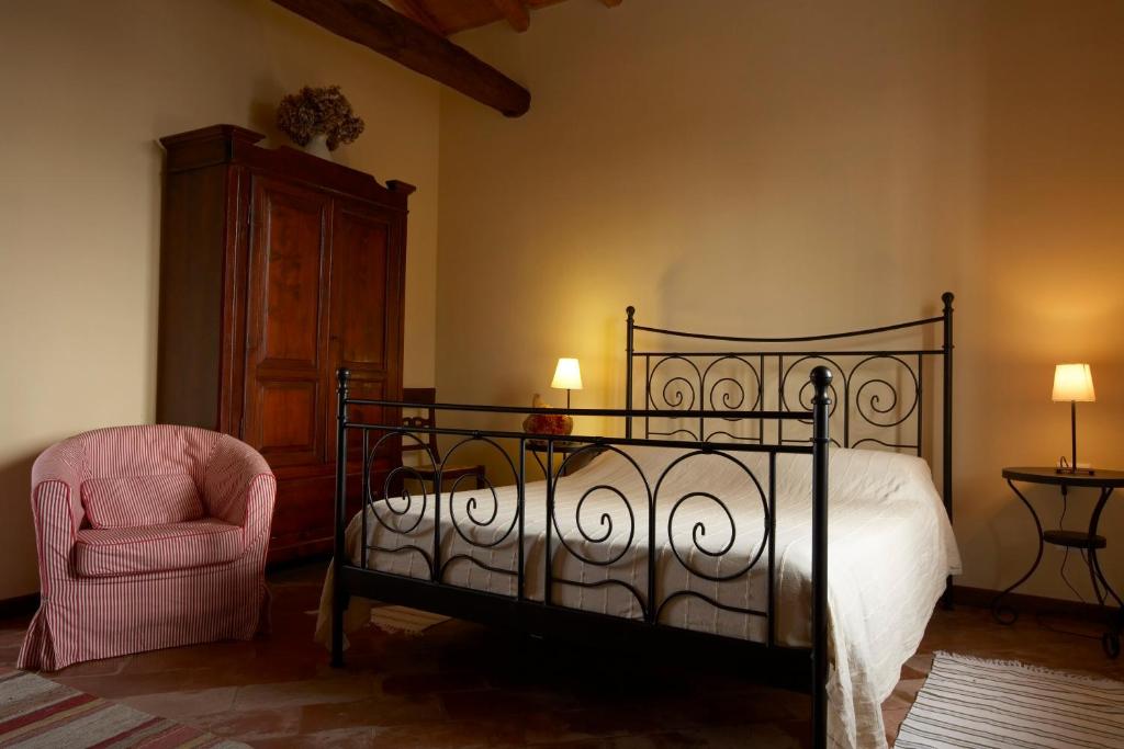 a bedroom with a bed and a chair at Cascina Scanna in Cisliano