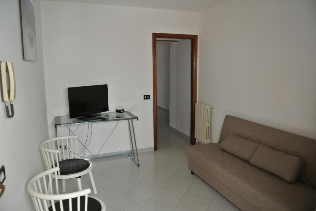 ein Wohnzimmer mit einem Sofa und einem Tisch mit einem TV in der Unterkunft Casa Vanni in Cefalú