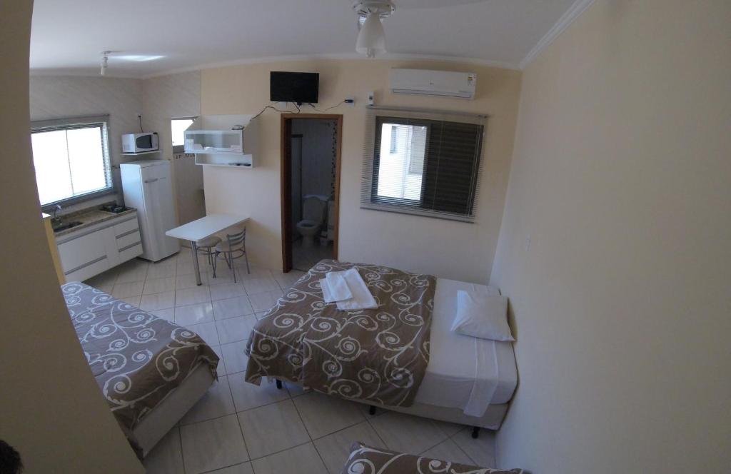 Habitación pequeña con cama y cocina en Áries Apart Hotel en Bauru