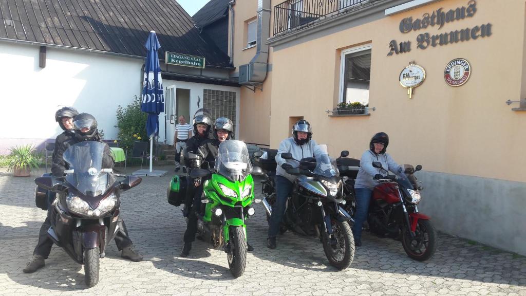 eine Gruppe von Personen auf Motorrädern, die vor einem Gebäude geparkt sind in der Unterkunft Gasthaus am Brunnen in Illerich