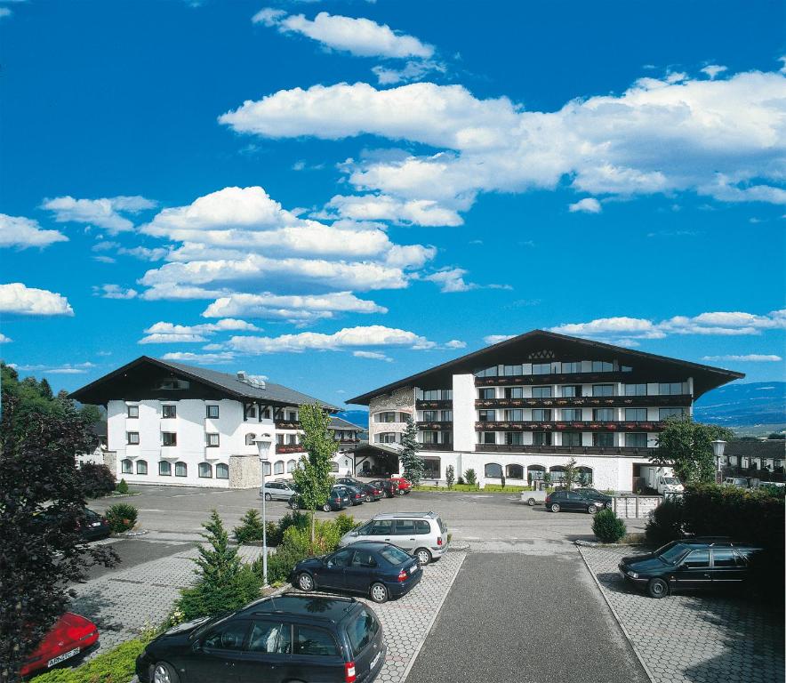 un estacionamiento con autos estacionados frente a un edificio en Hotel Lohninger-Schober en Sankt Georgen im Attergau