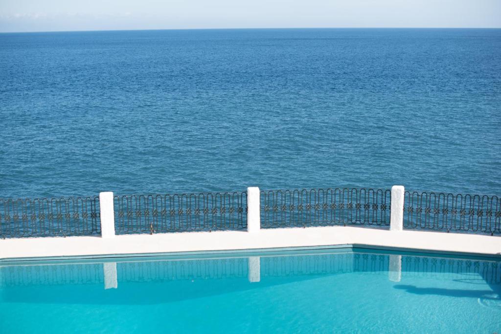 a swimming pool with the ocean in the background at Salt Water Villa in Santa Cruz