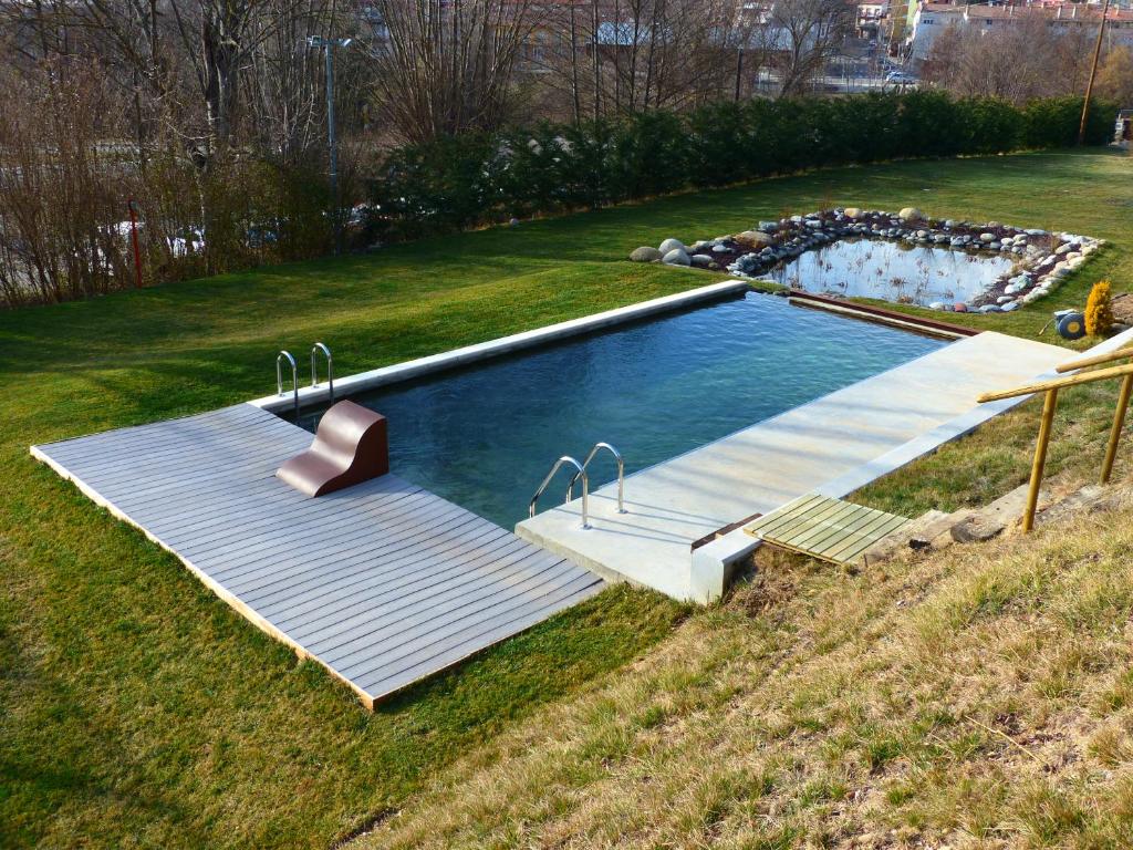 a swimming pool in the middle of a grass field at Casanova de Baix in Ripoll
