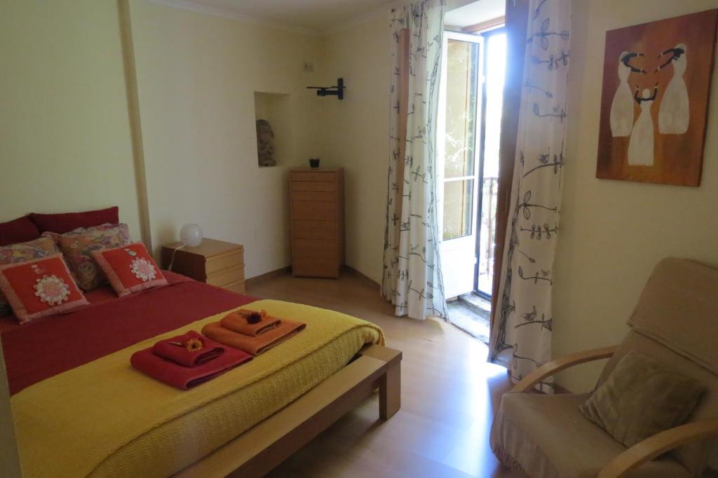 ein Schlafzimmer mit einem Bett, einem Stuhl und einem Fenster in der Unterkunft Alfama 28 Tram in Lissabon