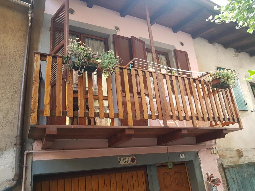 un balcón de madera en una casa con macetas. en Appartamento Speranza, en Pisogne