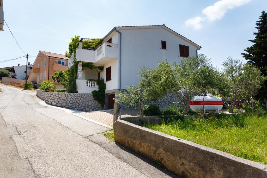 a white house on the side of a street at Apartments Jagoda in Vrbnik