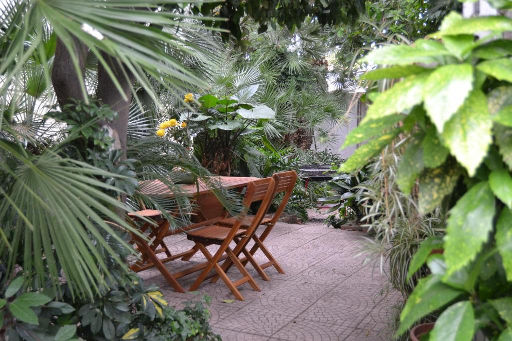 una mesa y sillas en un jardín con plantas en RELAX AL MARE - Spiaggia, bici e barbecue!, en Arma di Taggia