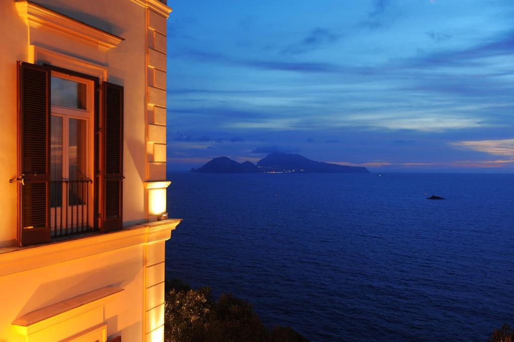 a building with a window overlooking the ocean at night at Villa Angelina in Massa Lubrense