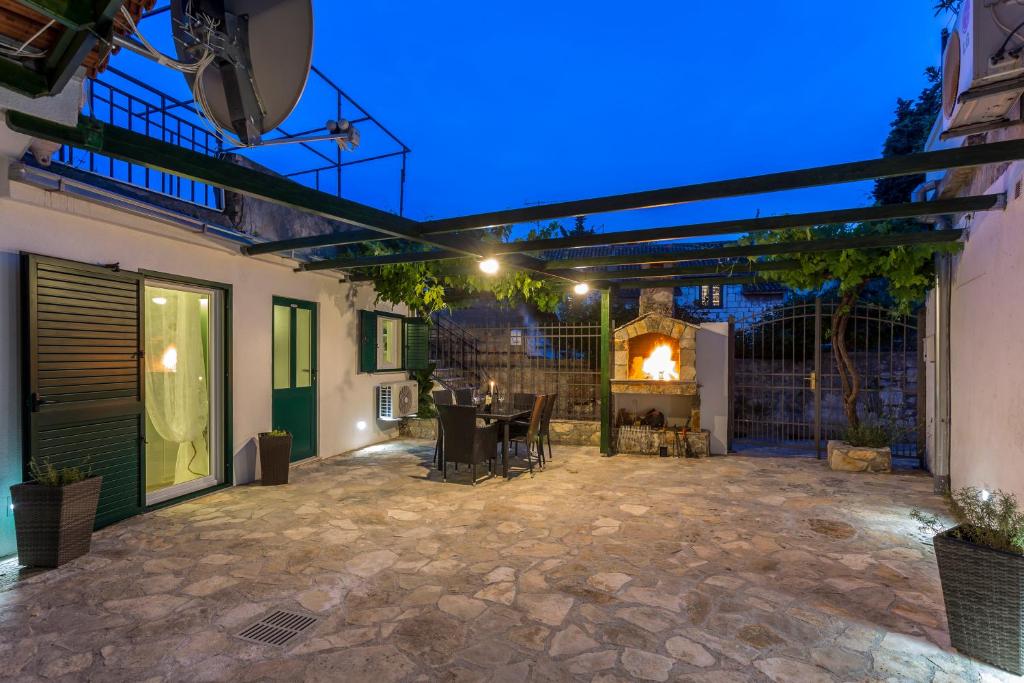 a patio with a table and a fireplace at night at Apartments Lavanda & Rozmarin in Split