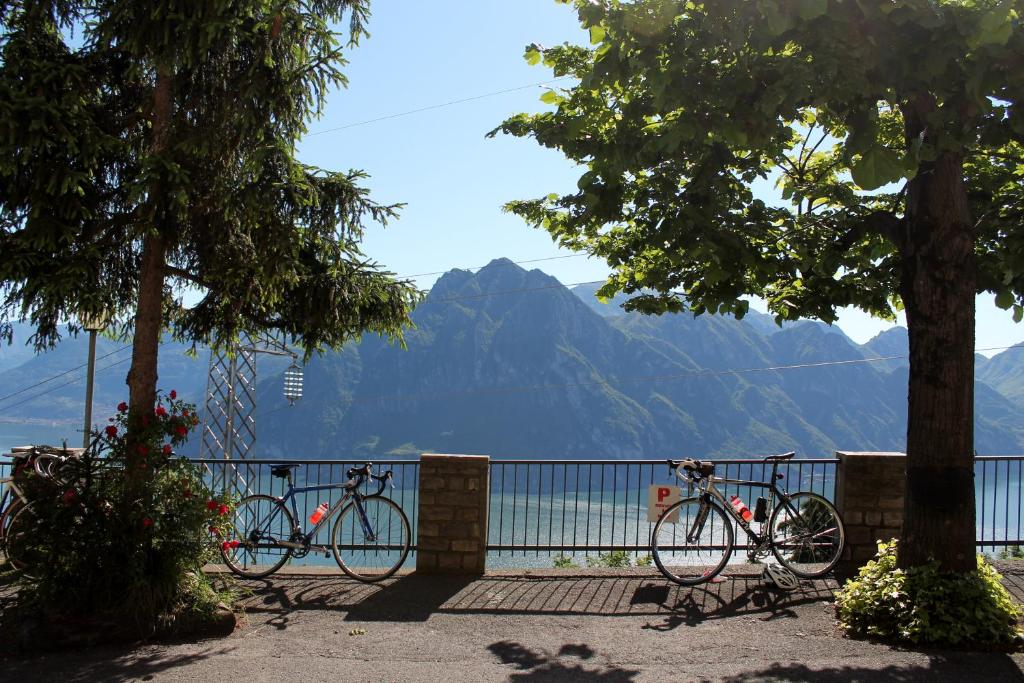 twee fietsen geparkeerd tegen een hek met bergen op de achtergrond bij Hotel Poggio d'Oro in Riva di Solto