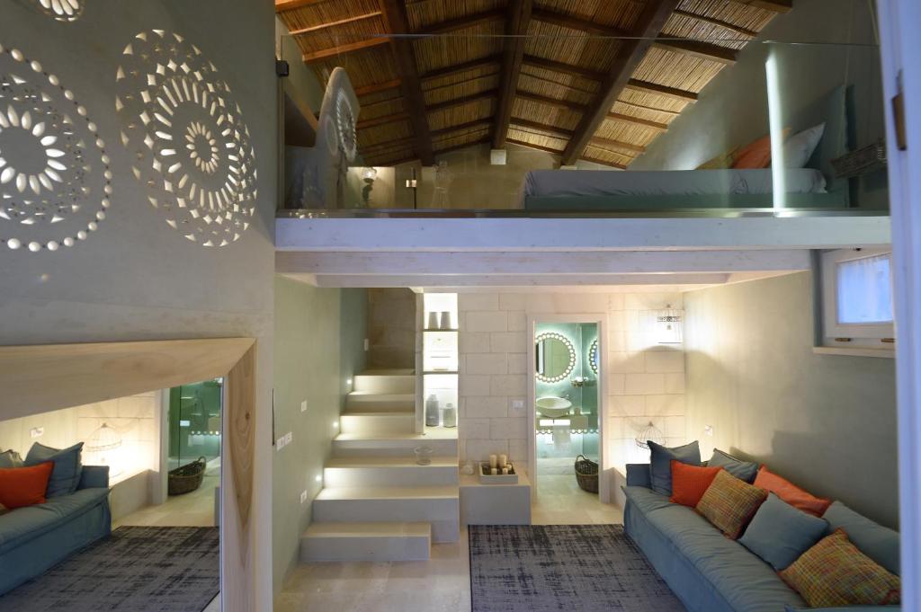 uma sala de estar com sofás azuis e uma escadaria em Corte Dei Granai em Maglie