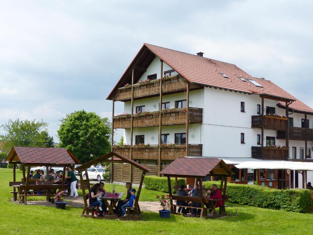 a group of people sitting outside of a large building at Grüner Baum in Külsheim