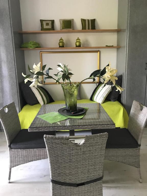a table with a vase of flowers on it at Residence Alexandra Stay in Sirmione