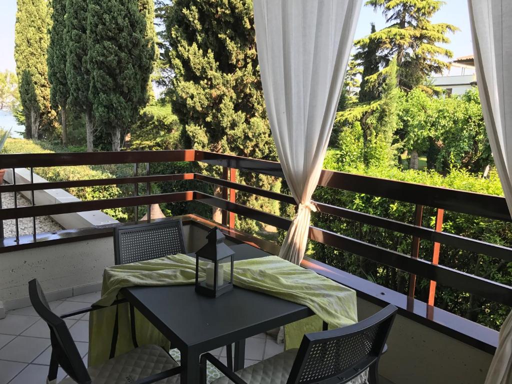 a balcony with a table and chairs and a window at Residence Alexandra Stay in Sirmione
