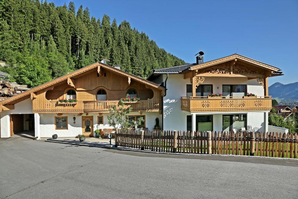 ein großes Haus mit einem Holzzaun davor in der Unterkunft Landhaus & Apartment Taxach in Ried im Zillertal