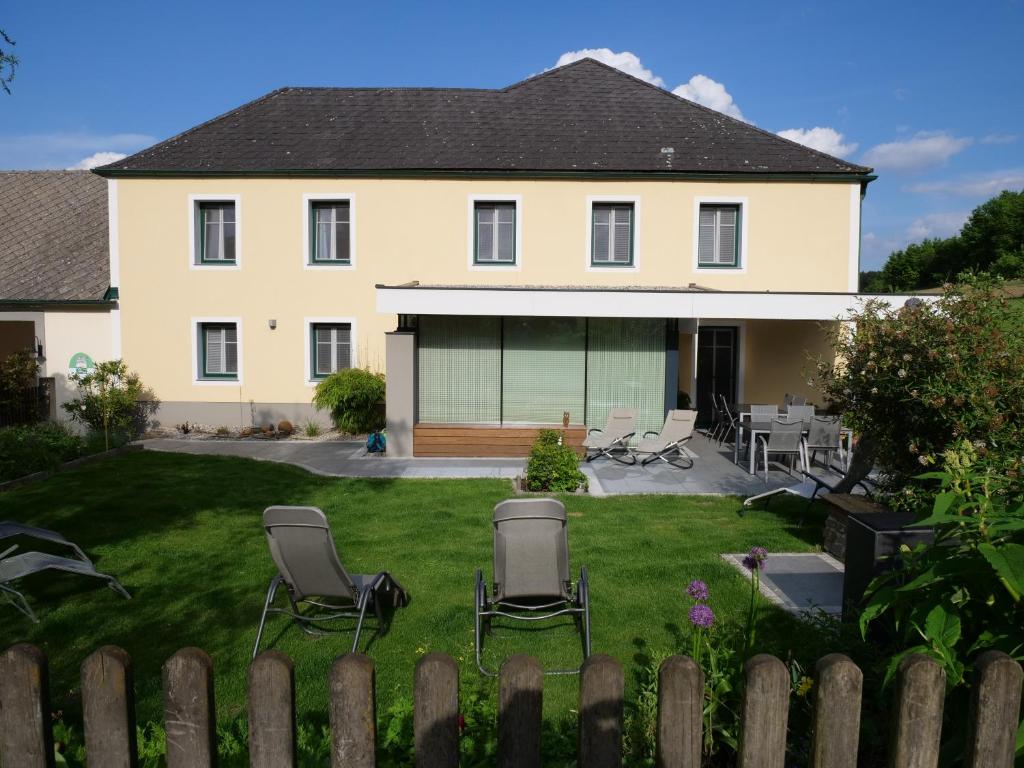 a house with a yard with chairs and a fence at Lugerfarm in Melk