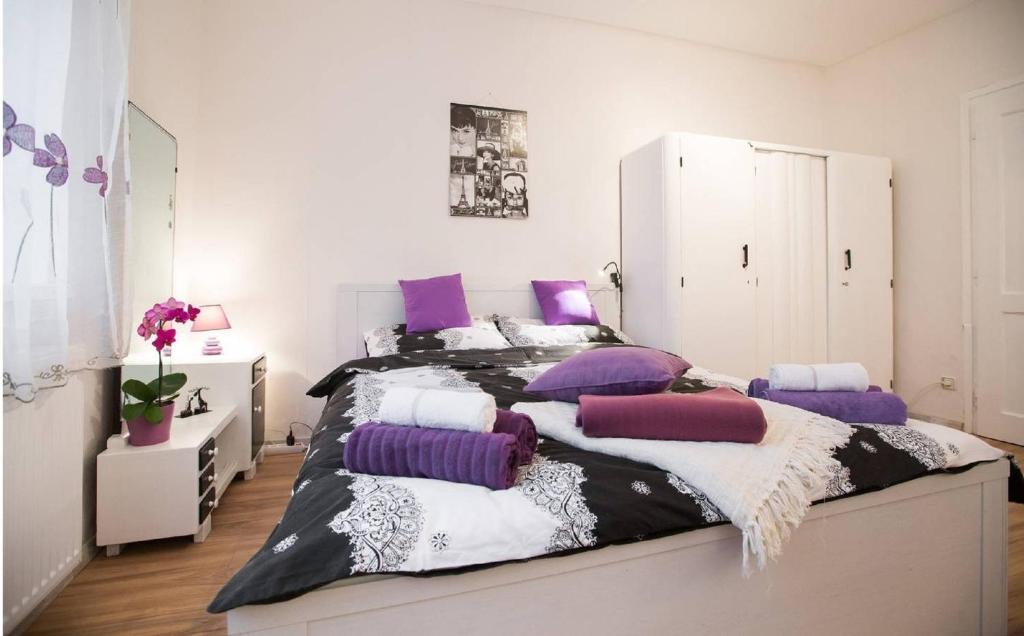 a bedroom with a large bed with purple pillows at Cute Apartment For You in Zagreb