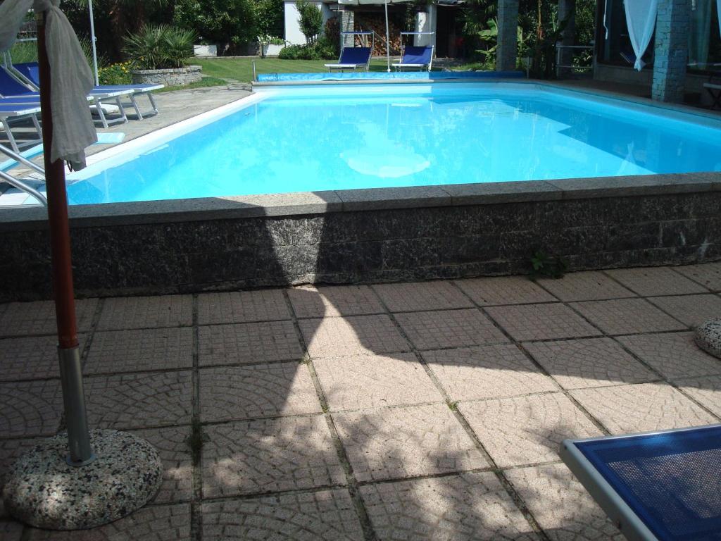 a large blue swimming pool with a tile floor at Residenza Le Palme in Caltignaga