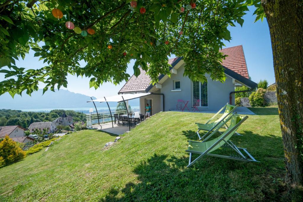 une maison sur une colline avec une chaise sur l'herbe dans l'établissement Gîte LaurieRaphael, à Pugny-Chatenod