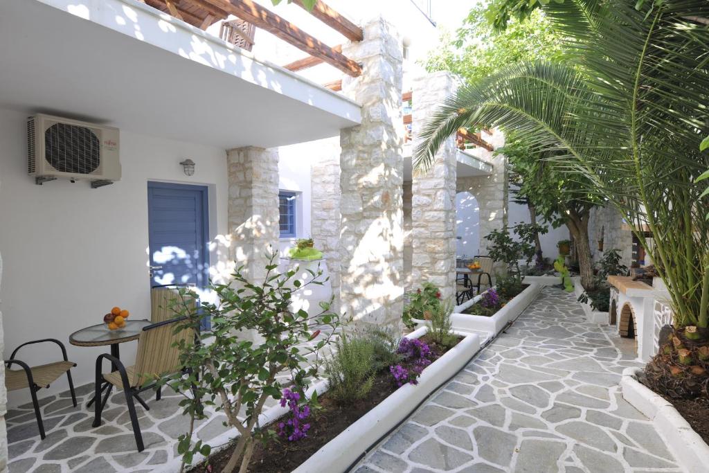 un cortile in una casa con tavolo e piante di Alexandros Studios a Naoussa