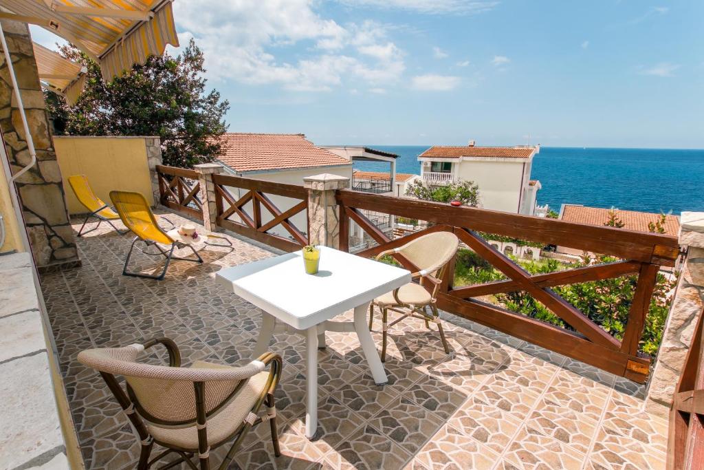 un patio con mesa, sillas y el océano en Holiday Home Siesta en Dobra Voda