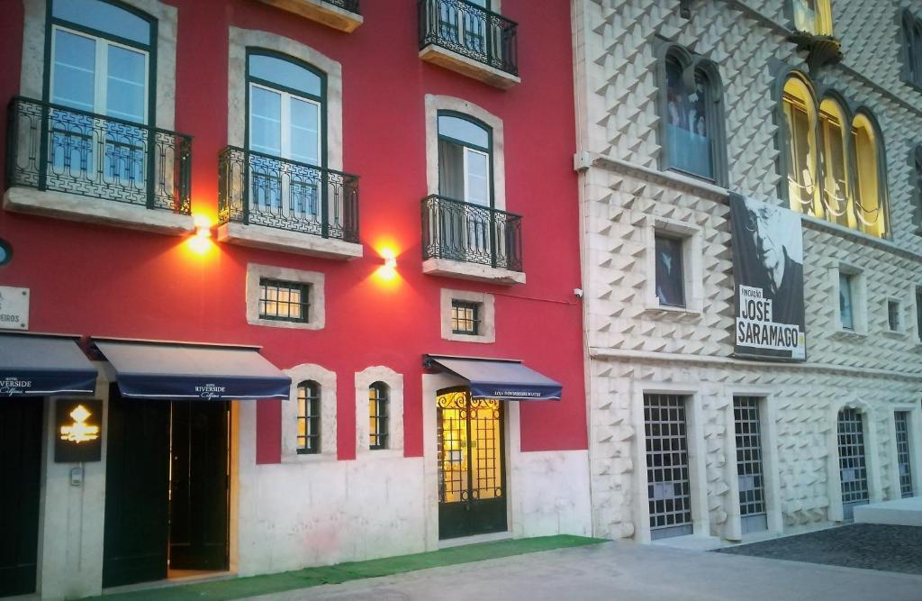 um edifício vermelho com janelas e varandas numa rua em Hotel Riverside Alfama em Lisboa