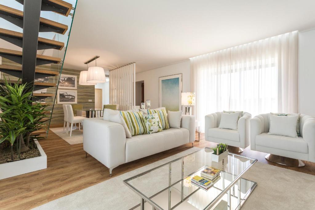 sala de estar con sofá blanco y mesa de cristal en Gallo`s House en Barcelos