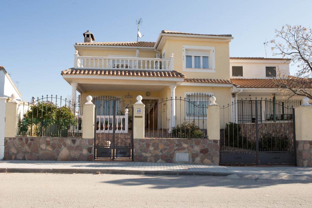 a white house with a gate and a fence at La Rosaleda de Orgaz in Orgaz